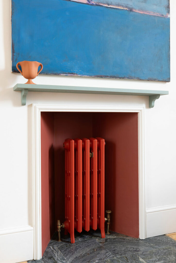 Beata Heuman Studios 188 Hammersmith Road red cast iron radiator in fireplace